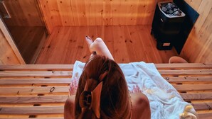 Une cabane en bois avec un lit, une fenêtre et une cheminée.