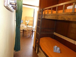 Ein Mehrbettzimmer mit einem Tisch und Stühlen im Hintergrund.