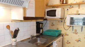 Keittiössä on mikroaaltouuni, kahvinkeitin ja roskakori.