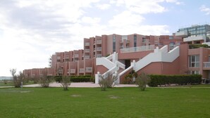 A modern building with a central staircase, surrounded by a well-maintained lawn and small shrubs. - Studio cabin with sea view, private parking (Sète)
