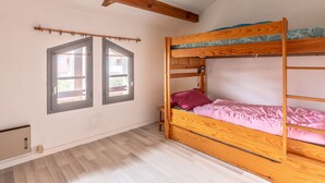 A bunk bed with a wooden frame, a window with a view, and a small wooden nightstand. - Cozy Maisonette 300m from Beach in Biscarrosse – Sleeps 4, Terrace, Parking (Biscarrosse)