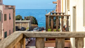 A coastal street with parked cars and buildings, overlooking the sea. - Foscolo 8 in Alghero (Alghero)