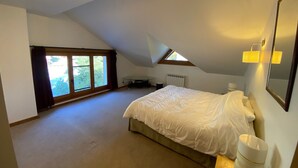 A bedroom with a large bed, a skylight, a radiator, and a window with curtains. - Spacious duplex for 20 near slopes in La Chapelle-d'Abondance (La Chapelle-d'Abondance)