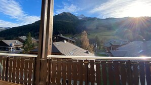 A wooden balcony overlooking a mountainous landscape with houses and a clear sky. - Spacious duplex for 20 near slopes in La Chapelle-d'Abondance (La Chapelle-d'Abondance)