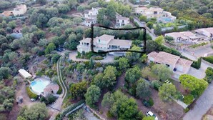 An aerial view of a residential area with houses, a swimming pool, and a hilly landscape. - Atypical house with sea view (Porto-Vecchio)
