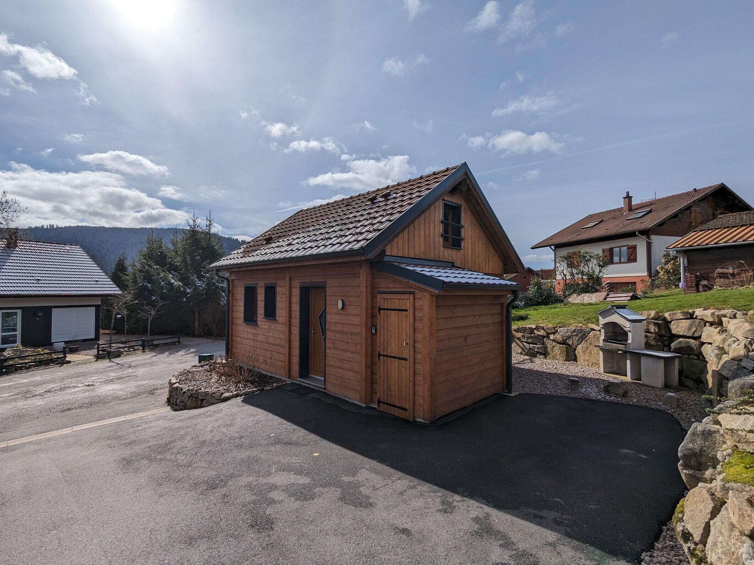 A wooden cabin with a sloped roof, a door, and a window.