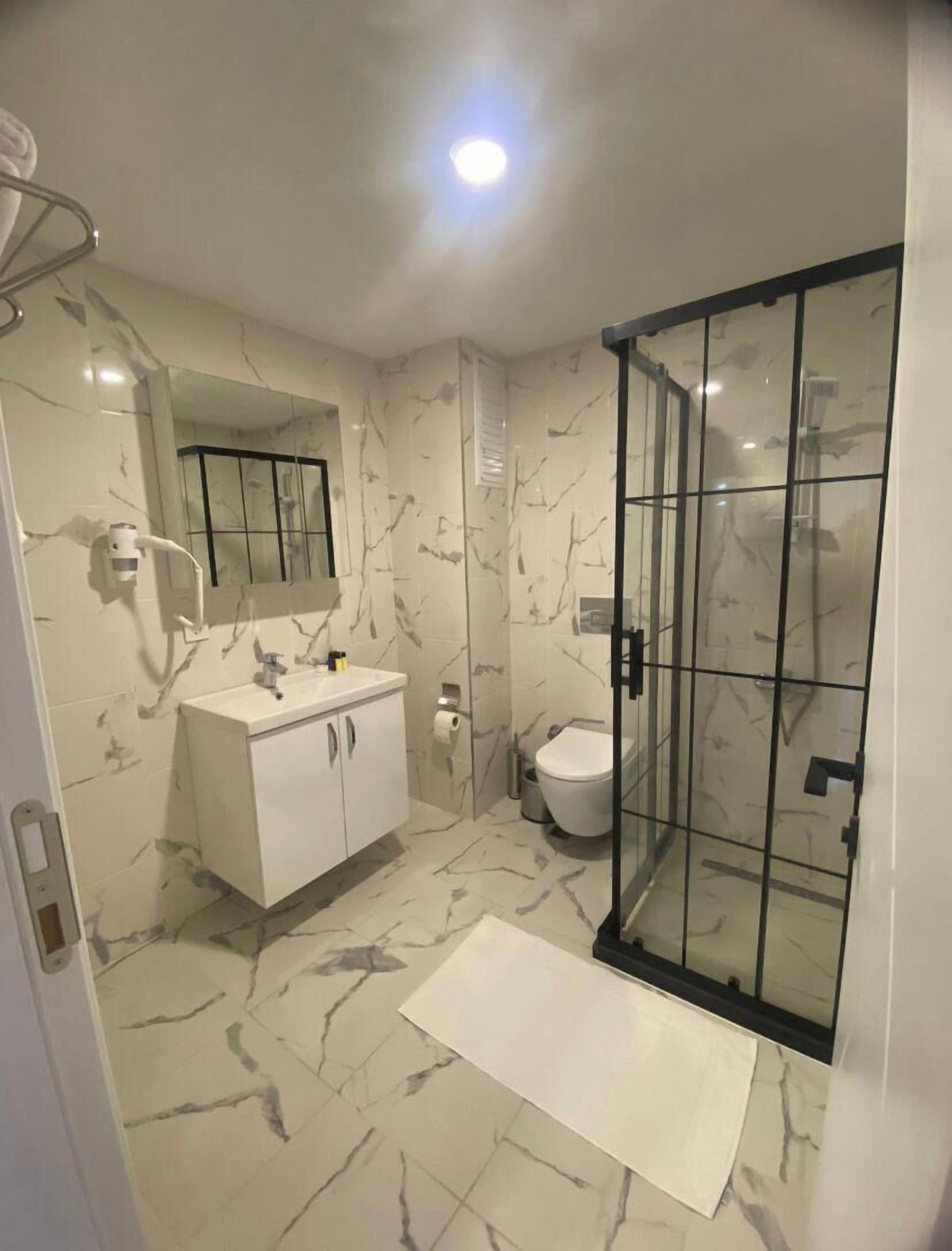 Een aparte badkuip en douche, een bubbelbad, een haardroger, pantoffels