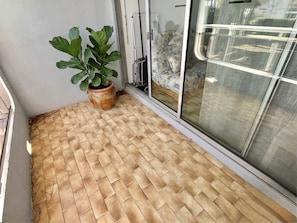 A room with a tiled floor, a potted plant, and a sliding glass door.