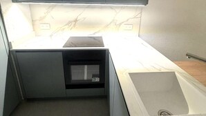 A compact kitchen with a built-in oven, a sink, and a marble backsplash. - Apartment in La Grande Motte with terrace and parking (La Grande-Motte)