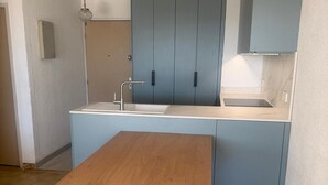 A kitchen with a sink, cabinets, and a wooden table. - Apartment in La Grande Motte with terrace and parking (La Grande-Motte)