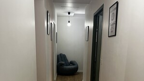 A narrow hallway with wooden flooring, a ceiling light, and a framed picture on the wall. - Little paradise in Aveyron (Saint-Jean-du-Bruel)