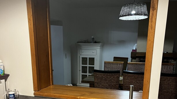 A kitchen with a grey countertop, a wooden table, wicker chairs, and a hanging light fixture. - Little paradise in Aveyron (Saint-Jean-du-Bruel)