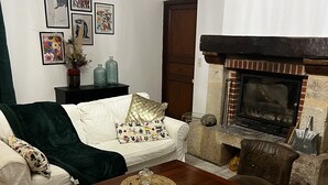 A living room with a fireplace, a sofa, a coffee table, and a chair. - Little paradise in Aveyron (Saint-Jean-du-Bruel)