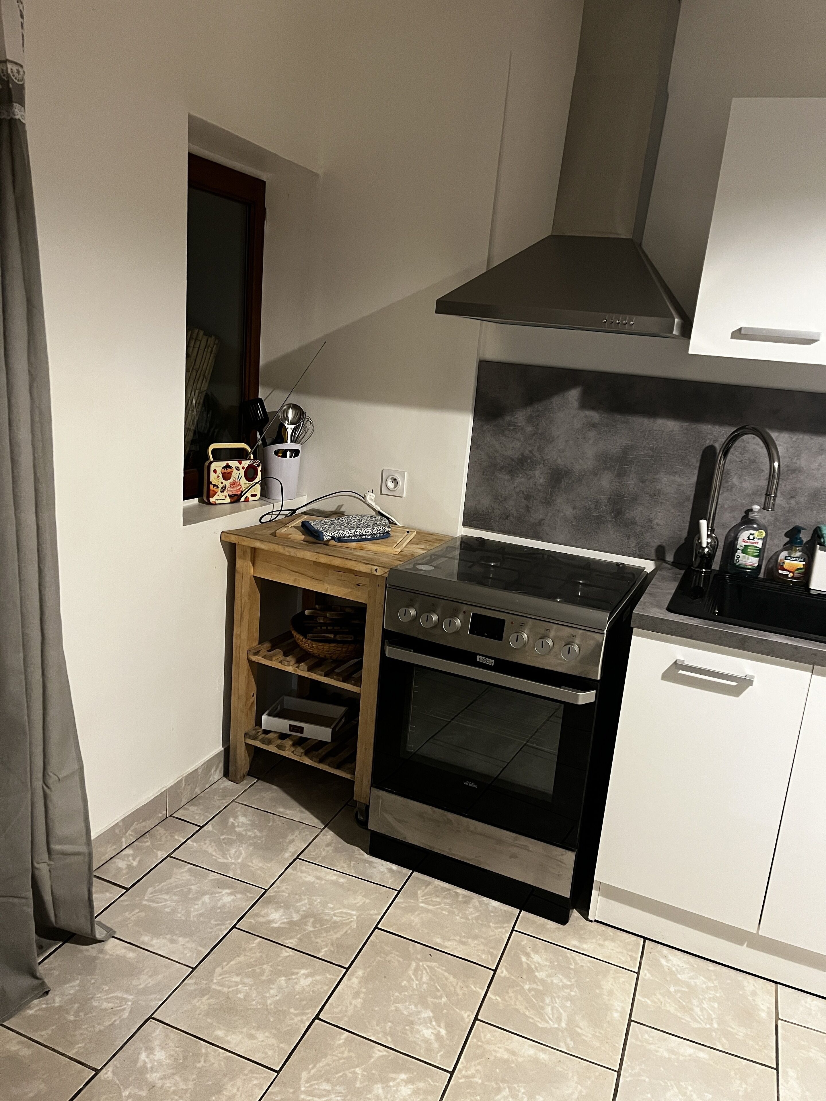 Eine kompakte Küche mit Backofen, Kochfeld und Spüle.