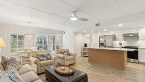 A spacious living room with a large island, beige sofas, and a coffee table. - Pet Friendly | Ground Floor Sailmaker Villa | Covered Patio with Pool View (Fernandina Beach)