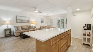 A spacious living area with a large island, a sofa set, and a dining table. - Pet Friendly | Ground Floor Sailmaker Villa | Covered Patio with Pool View (Fernandina Beach)