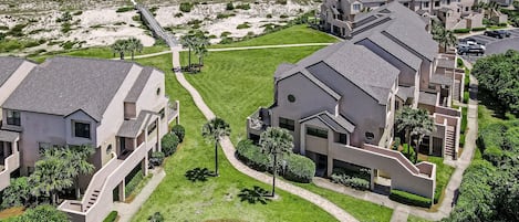 A coastal residential area with modern houses, a beach, and a boardwalk.