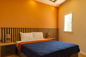 A bedroom with a bed, two bedside tables, a window, and a ceiling light.
