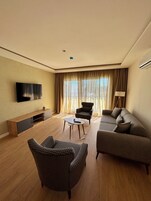 Apartamento Deluxe | Zona de estar | Televisión de plasma de 80 pulgadas con canales por satélite