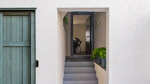 Un escalier menant à une pièce dotée d’une porte et d’une plante en pot.