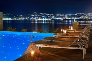 An infinity pool with a city view at night. - Sea la vie Villa Private Pool (Mykonos)