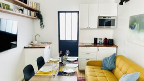 Un espace de vie compact comprenant un coin repas, une kitchenette et un canapé.
