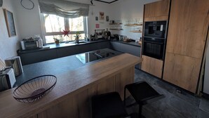 Una cocina moderna con una isla central, armarios de madera y un horno empotrado.