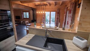 Eine Küche mit Spüle, Toaster und Fenster mit Blick auf einen Garten.