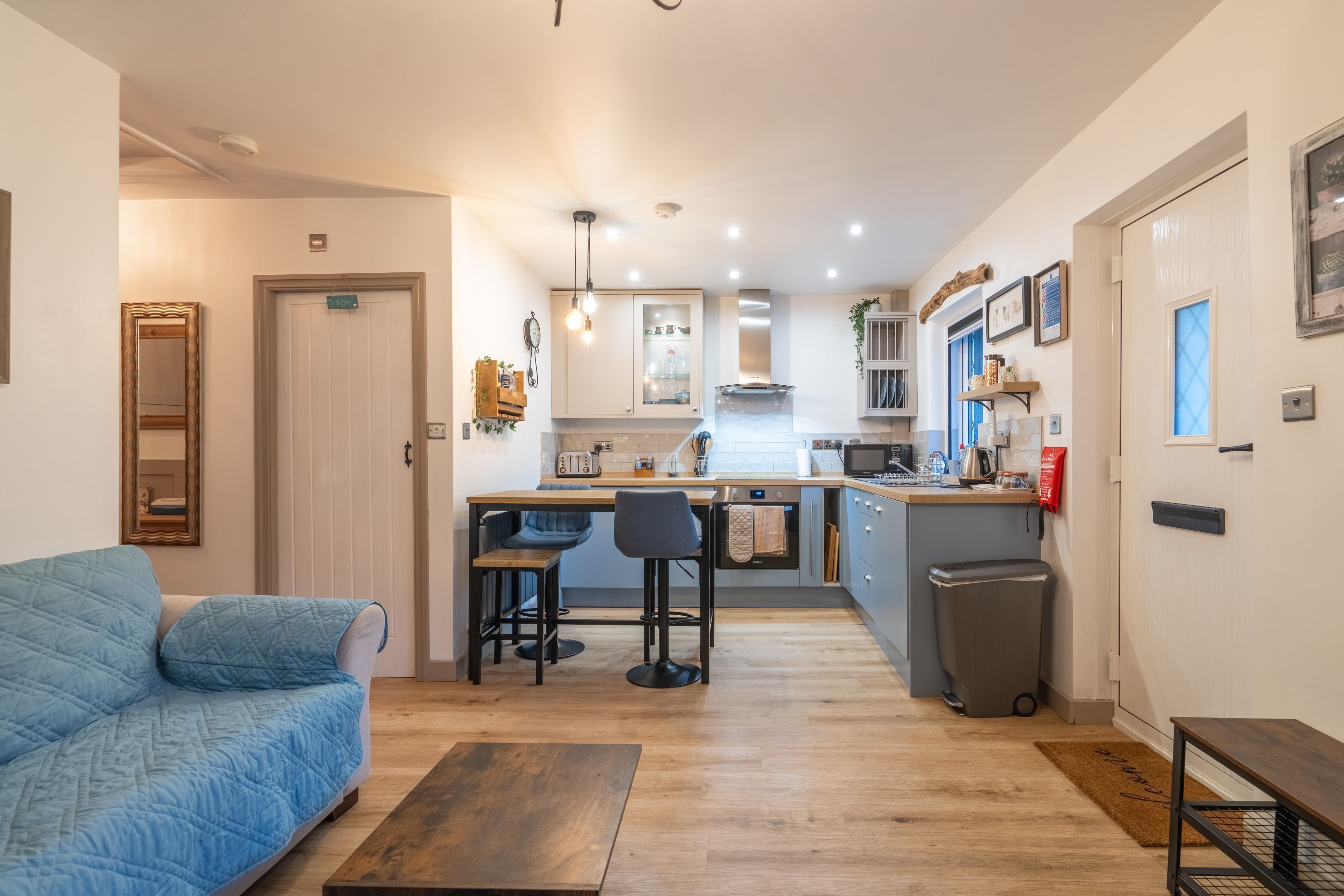 Un espacio habitable compacto con kitchenette, un sofá y zona de comedor.