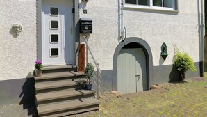 A building with a white exterior, a set of steps leading to a door, and a mailbox.