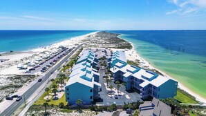 A resort with a central building, parking, and a beach. - Escape to paradise at Palm Beach Club #217/Sound Front Condo! (Pensacola Beach)