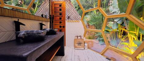 A bathroom with a wooden bench, a mirror, and a wooden door.