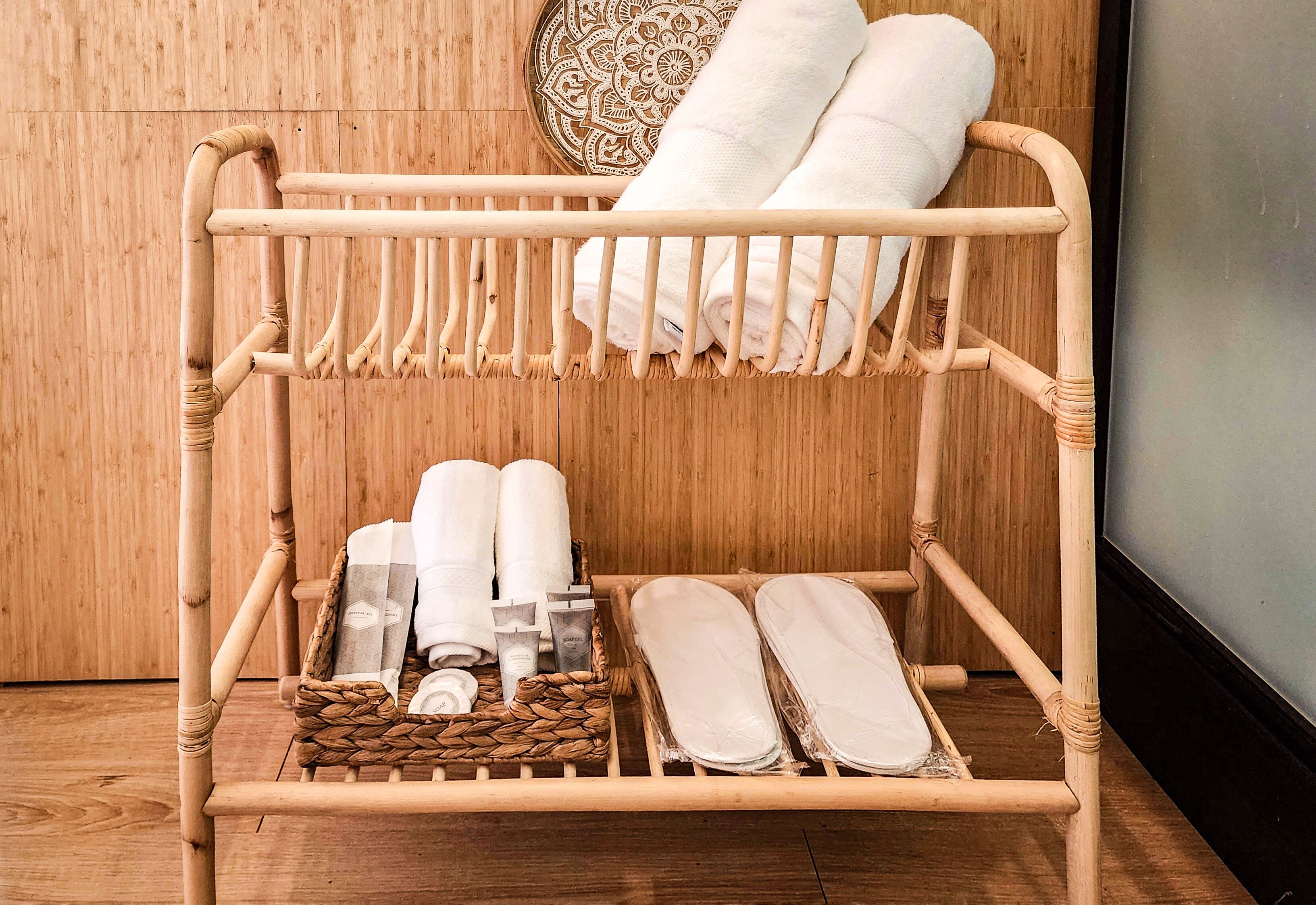 Portasciugamani in bambù con asciugamani e articoli da toilette.