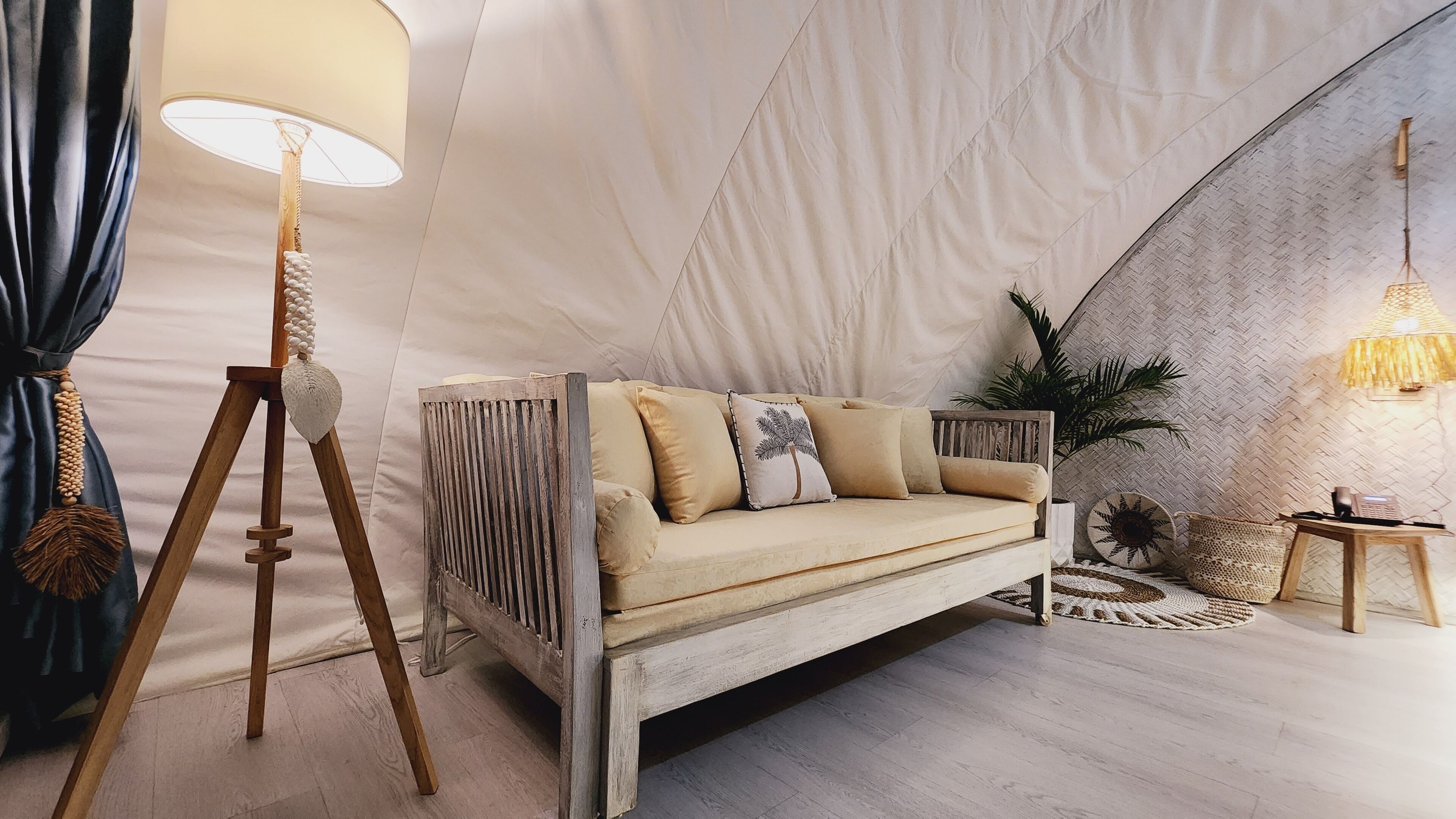 Ein gemütliches Zimmer mit einer Holzsofa, einer Lampe und einem gewebten Teppich.