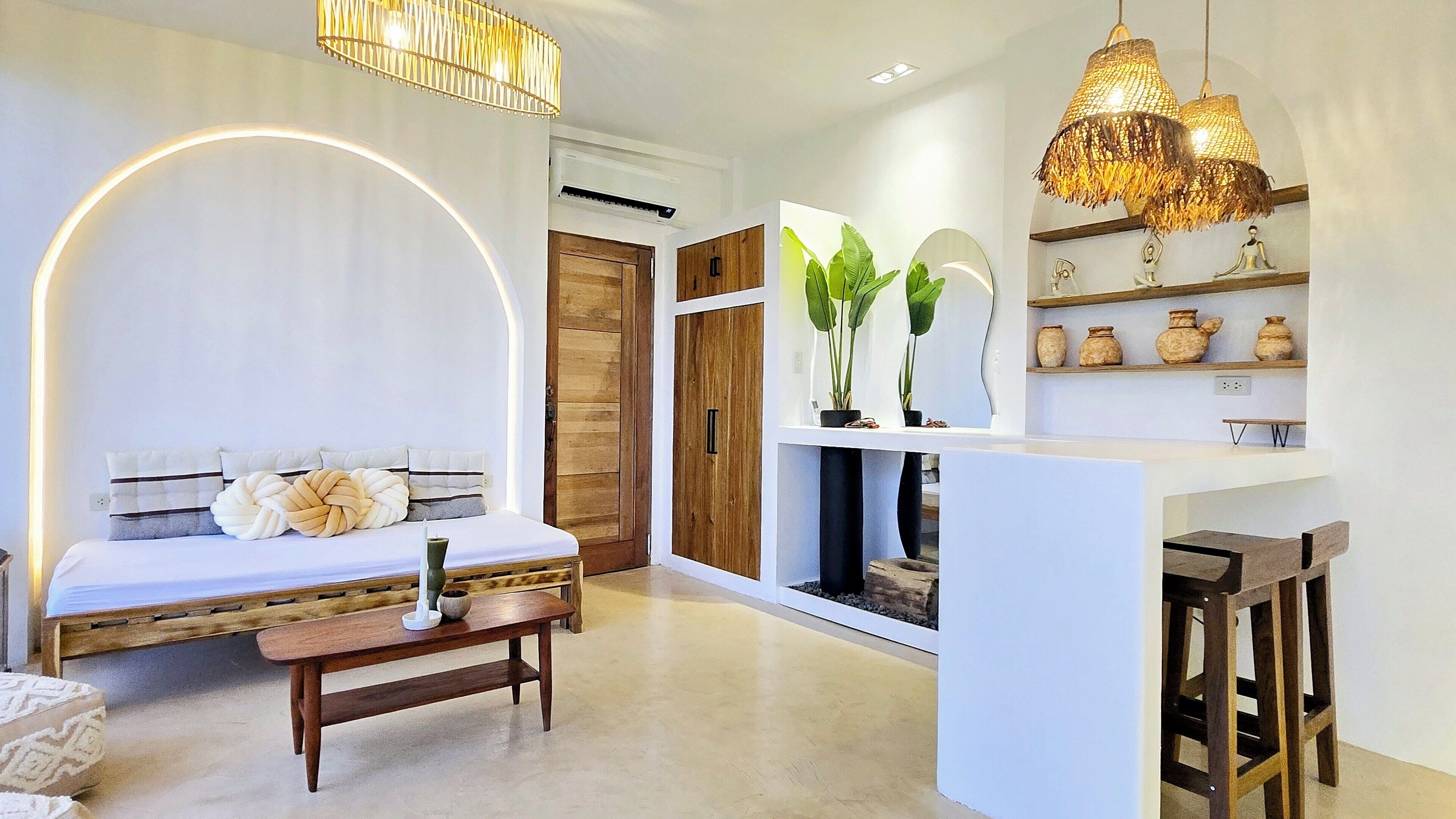 A modern living room with a sofa, a coffee table, and a bookshelf with decorative items.