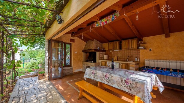 A cozy outdoor dining area with a table set for two, a wooden bench, and a foosball table. - Little apartment near the beach - Aleks 3 (Umag)