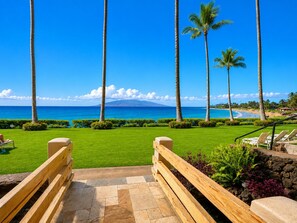 A resort view with a clear sky, palm trees, and a beach.