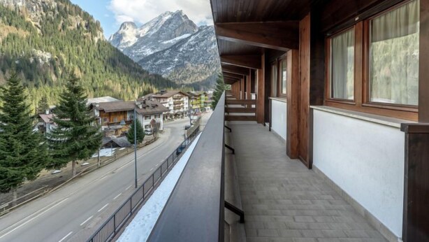 A balcony with a view of a mountain road and buildings. - Condominio Giulia by Interhome (Canazei)