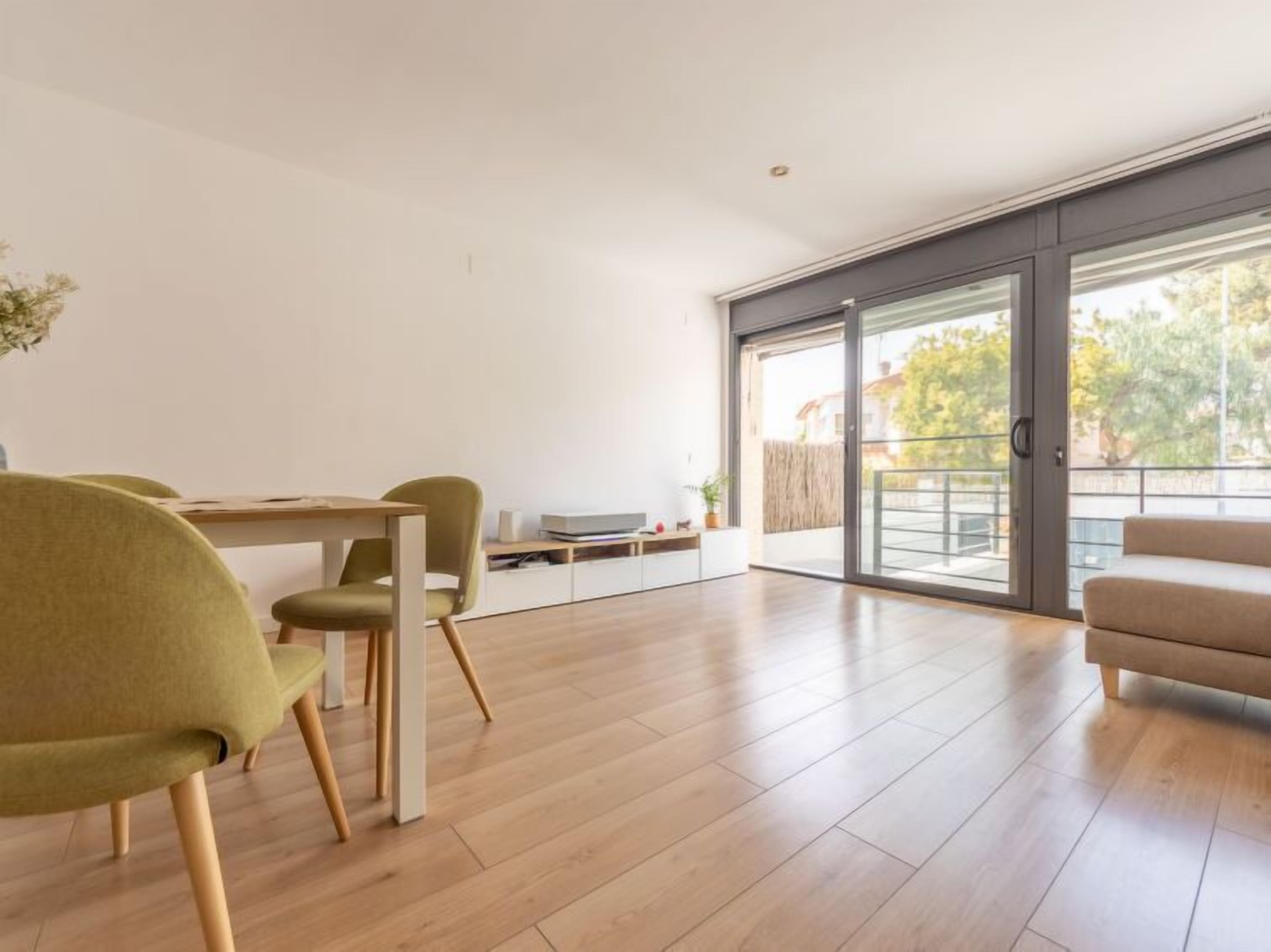 Ein modernes Wohnzimmer mit Essbereich, großen Schiebeglasfenstern zum Balkon und minimalistischem Design.