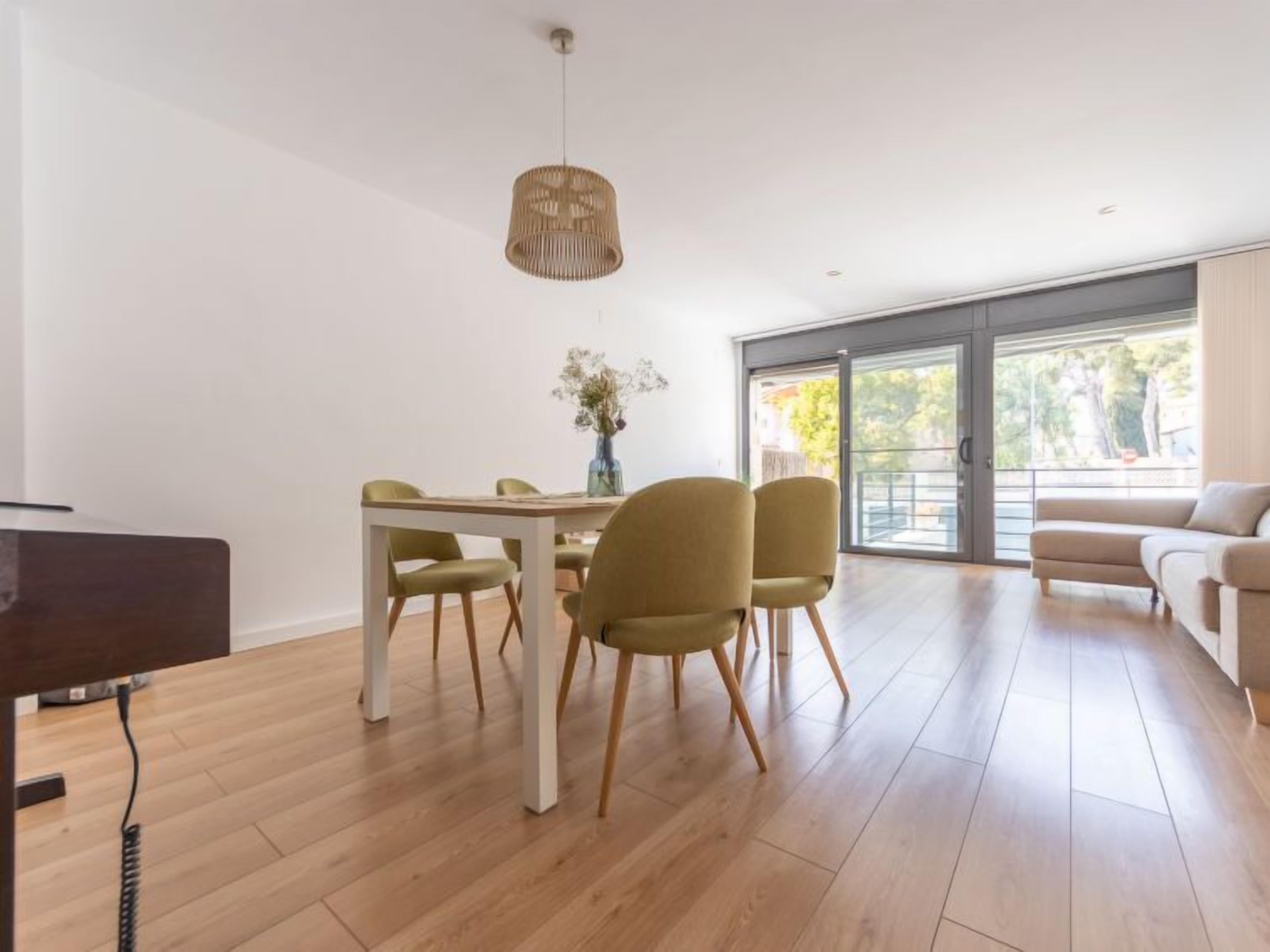 A spacious living area with a dining table, chairs, and a sofa.