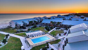 Un resort con piscina, vista sulla spiaggia e diversi edifici con tetti blu.