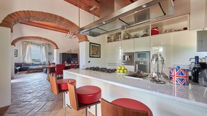 Una cocina moderna con una isla central, electrodomésticos de acero inoxidable y vistas al área de estar.
