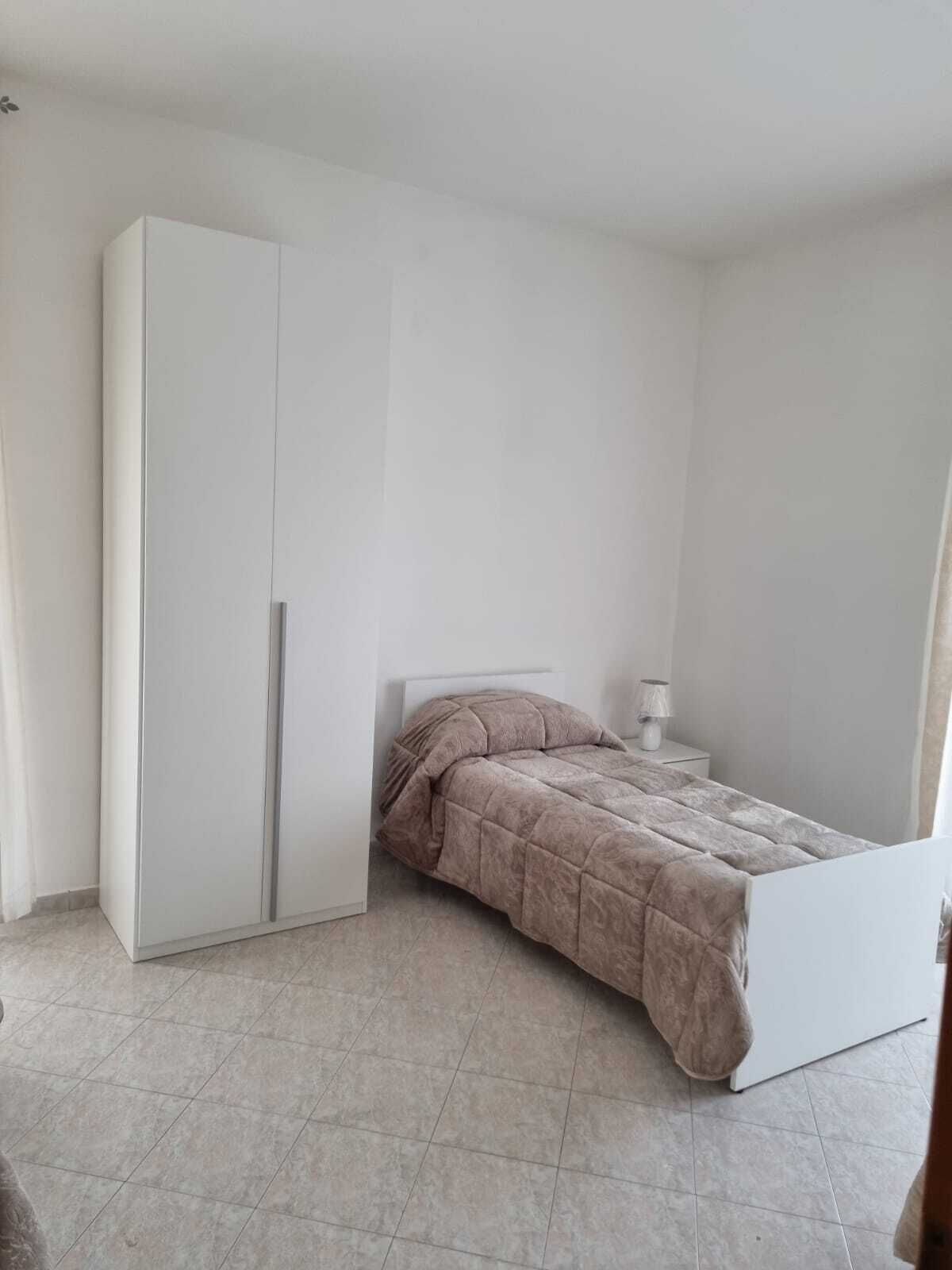 Ein Schlafzimmer mit einem Bett, einem Kleiderschrank und einem Nachttisch.