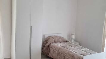 Ein Schlafzimmer mit einem Bett, einem Kleiderschrank und einem Nachttisch.