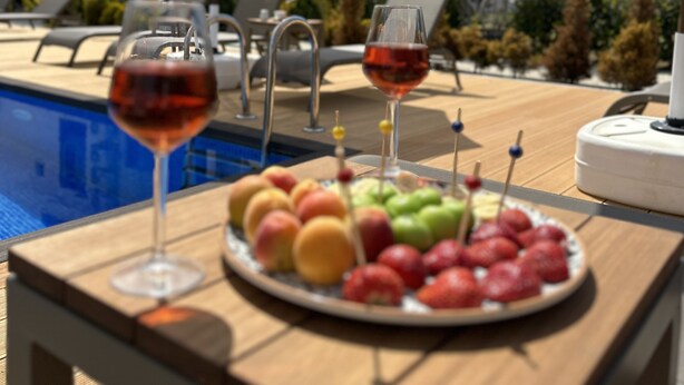 A poolside table with two wine glasses and a fruit platter. - No 48 Alaçatı  (Cesme)