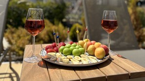 A wooden table with two wine glasses and a fruit platter. - No 48 Alaçatı  (Cesme)