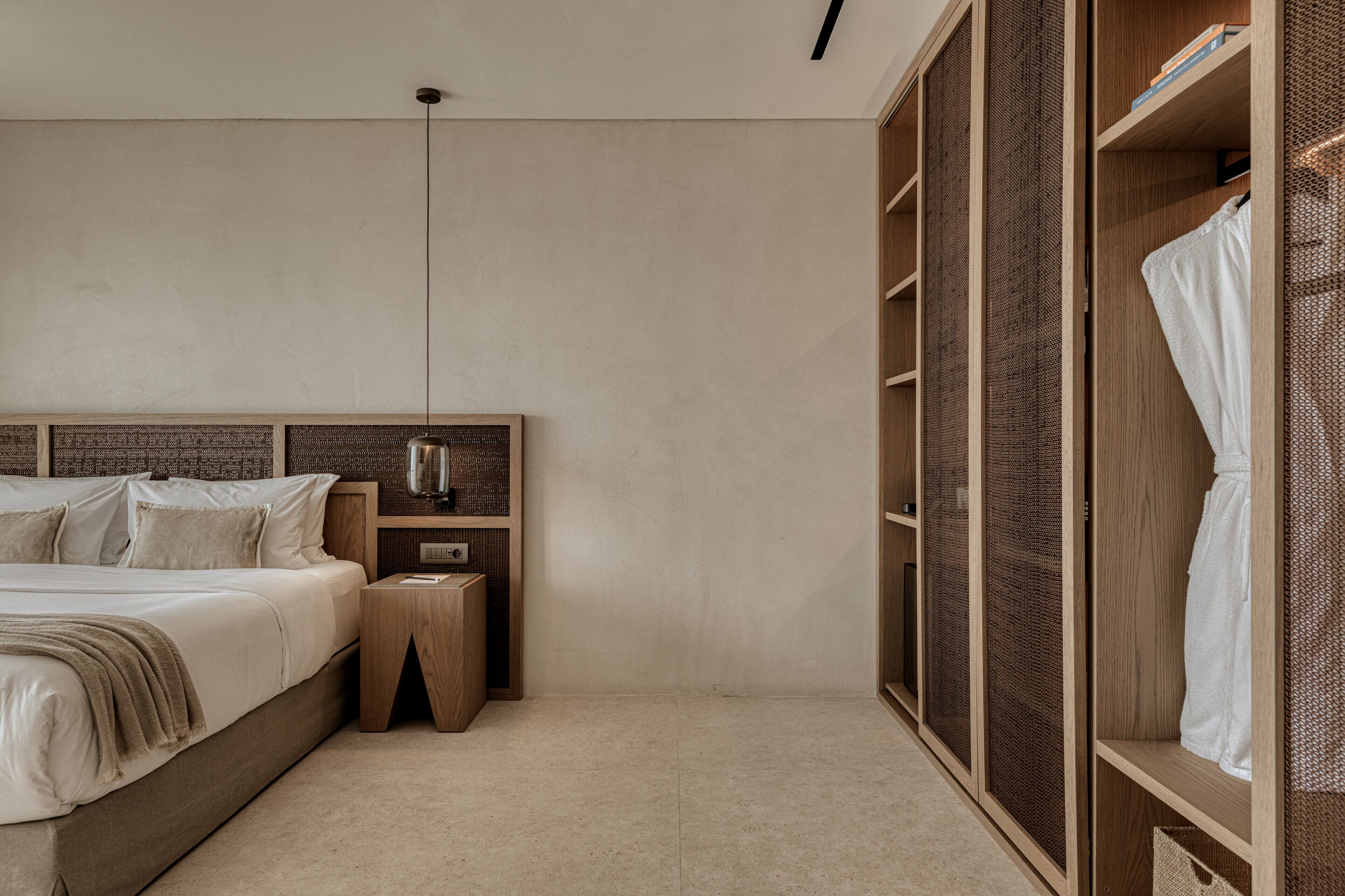 A bedroom with a bed, bedside table, and a wardrobe with a mirror.