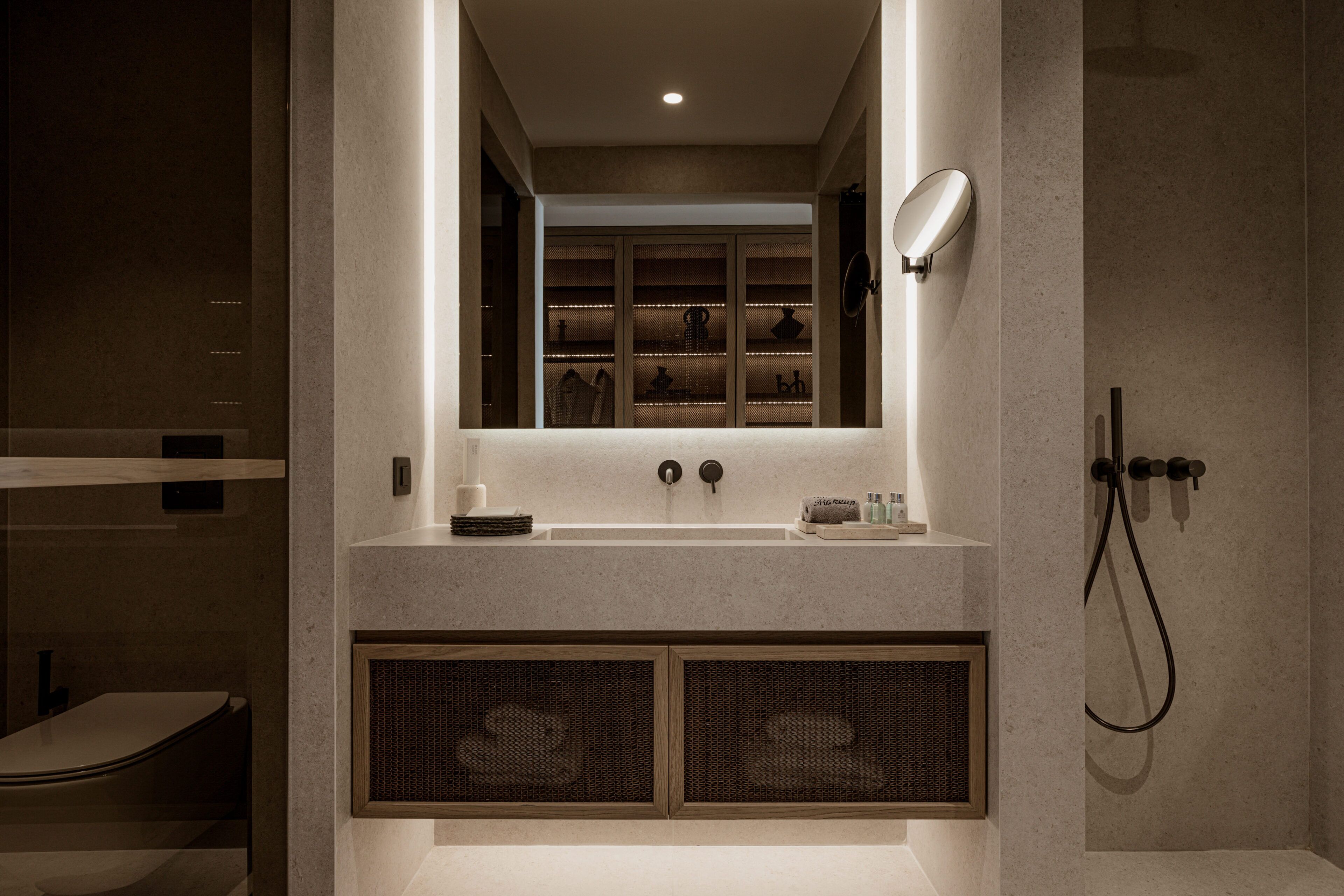 A modern bathroom with a built-in sink, a mirror, and a shower area.