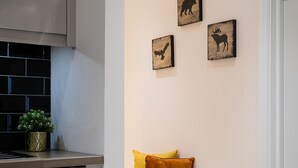A modern kitchen with a built-in stove, a white towel hanging on the door, and a small plant on the counter. - Designer 2-bed 2-bath apartment with a garden (London)