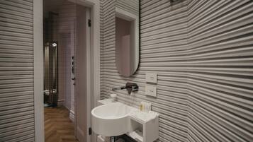 Une salle de bain moderne avec un grand lavabo, un miroir et un motif rayé sur le mur.